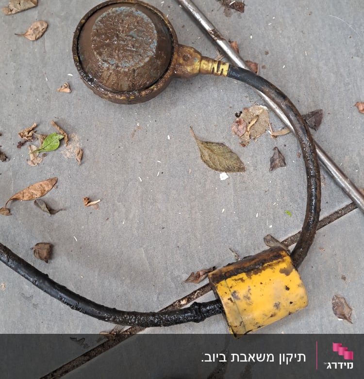 כלי עבודה חלוד עם כבל צהוב על רצפה